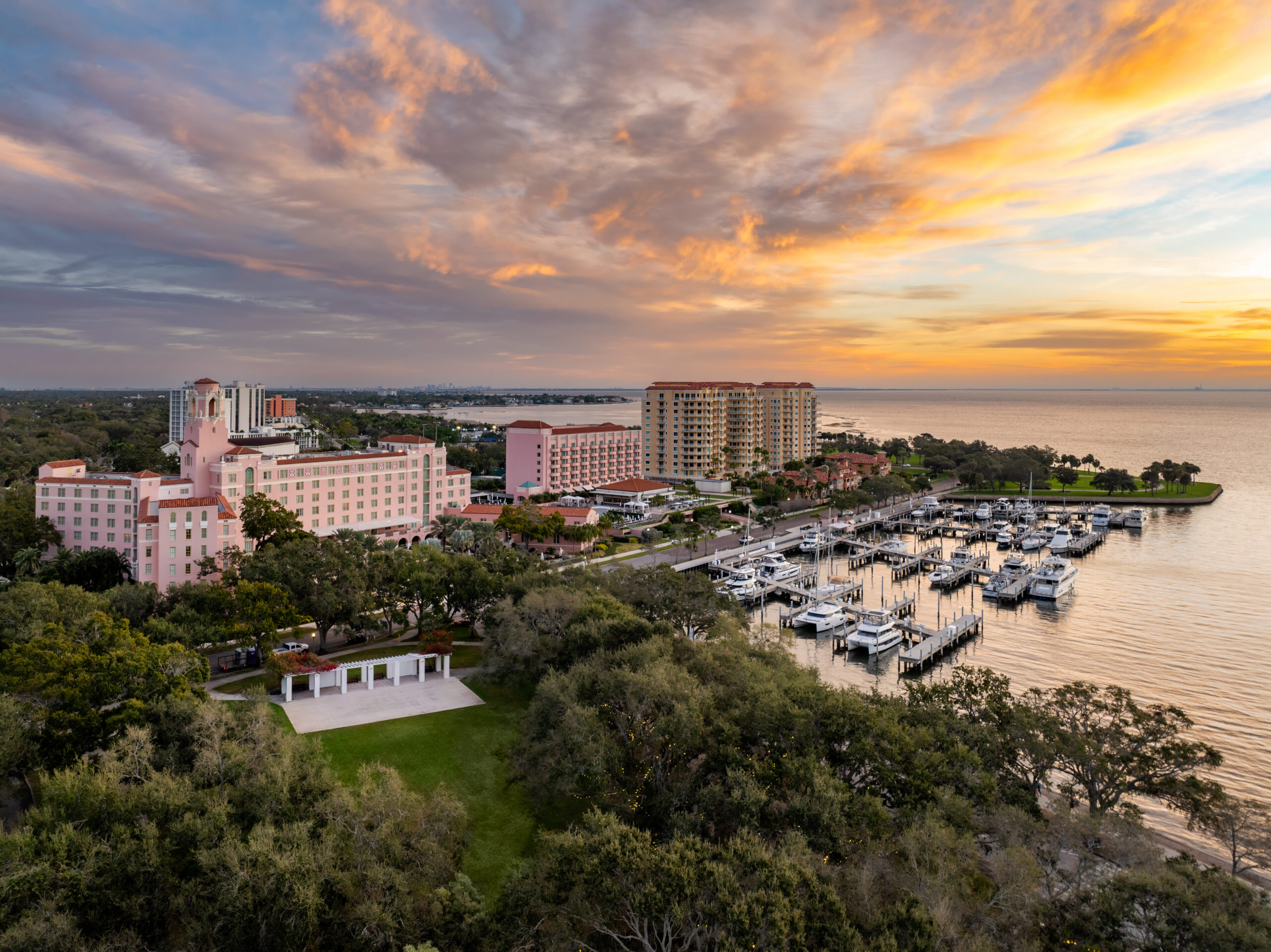 The Vinoy exterior viewed from the bayfront, showing the property's arched arcade and palm-lined approach.